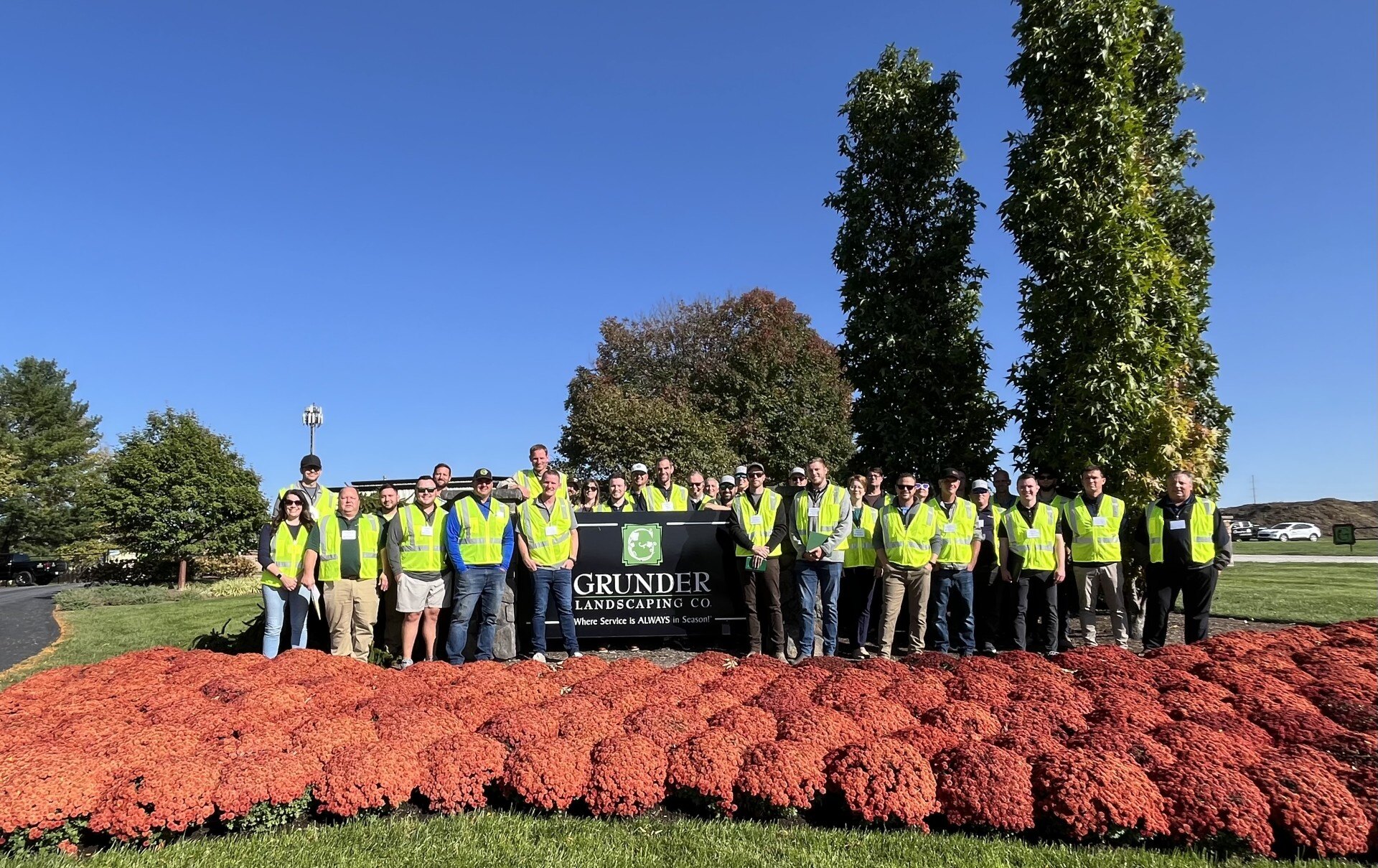 The grunder landscaping employees taking a group photo, everyone wearing safety vests 